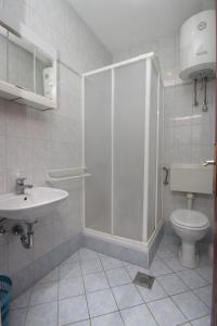 a bathroom with a shower and a toilet and a sink at Triple Room Metajna 6378d in Metajna
