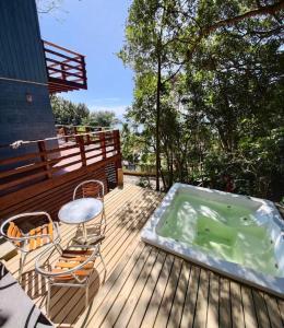 bañera de hidromasaje en una terraza con mesa y sillas en Double Deck - Linda vista com Jacuzzi en Palhoça