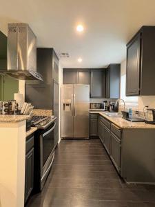 a large kitchen with stainless steel appliances and wooden floors at Hollywood Green Habitat in Los Angeles