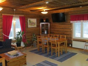 NaamijokiにあるMyllyn Pirtti Cottageのリビングルーム(テーブル、椅子、テレビ付)