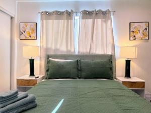 a bedroom with a green bed with two lamps at Hollywood Green Habitat in Los Angeles
