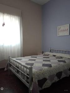 1 dormitorio con 1 cama con manta a cuadros en Ayres de Miramar en Miramar