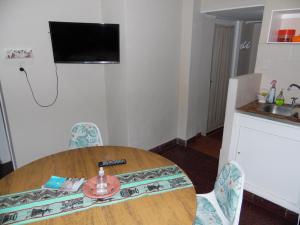 una mesa y sillas en una cocina con TV en Ayres de Miramar en Miramar