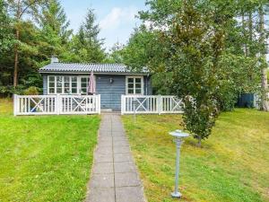 a tiny house in a yard with a white fence at 5 person holiday home in Ans By in Roe