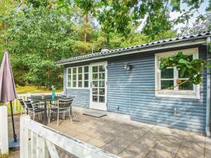 uma pequena casa azul com uma mesa e cadeiras em 5 person holiday home in Ans By em Roe