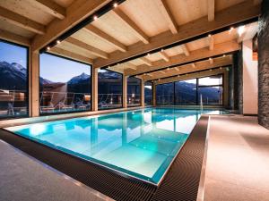 a swimming pool in a house with mountains at Sonja Alpine Resort in Piesendorf