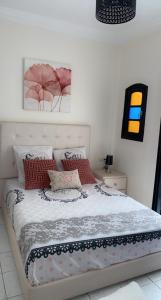 um quarto com uma cama com almofadas vermelhas em Riad Lyna em Marrakech