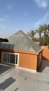 a building with a roof with palm trees in the background at Riad Lyna in Marrakech
