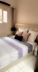 a bedroom with a large bed with pink and white pillows at Riad Lyna in Marrakech
