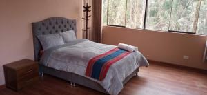 a bedroom with a bed and two windows at Maychu's Albergue in Chinchero