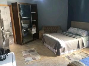 un dormitorio con una cama y un sofá en Suite/loft Jardim Botanico, en Curitiba