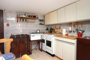 uma cozinha com armários brancos e um forno com placa de fogão em Twin Room Podaca 6824c em Podaca