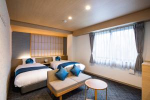 京都的住宿－Rinn Niomon，酒店客房设有两张床和窗户。