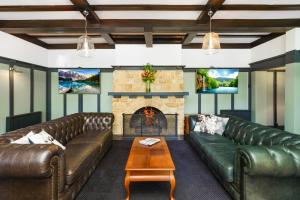 a living room with leather couches and a fireplace at Bundanoon Hotel in Bundanoon
