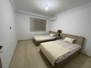 1 dormitorio con 2 camas y ventana en Palm Lake Resort Folla Monastir/Sousse, en Monastir