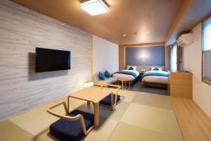 ein Hotelzimmer mit 2 Betten und einem TV in der Unterkunft Rinn Niomon in Kyoto