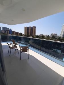2 sillas y una mesa en el balcón de un edificio en Apartamento Santa Marta Bello Horizonte Junto a Olímpica, en Santa Marta
