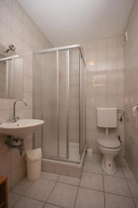 łazienka z prysznicem, toaletą i umywalką w obiekcie Apartment Mandre 6405b w mieście Kolan