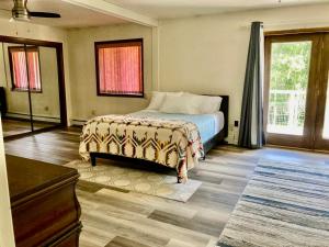 1 dormitorio con 1 cama, vestidor y ventanas en Spacious Resort Style Retreat Sleeps 20 en Fairbanks