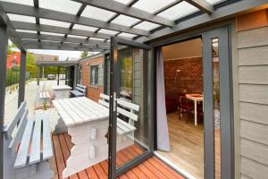 a screened in porch with a pergola and a bench at Tiny Modern Houses for 5 persons in Dziwnow with parking space in Dziwnów
