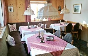 ライト・イム・ヴィンクルにあるGästehaus Annemarieのピンクと白のテーブルクロスが飾られたテーブル2台付きのレストラン