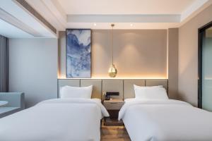 Ліжко або ліжка в номері Xinhuating Business Hotel