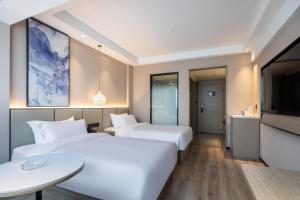 Ліжко або ліжка в номері Xinhuating Business Hotel
