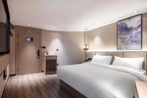 Ліжко або ліжка в номері Xinhuating Business Hotel