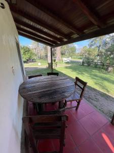 een houten tafel en stoelen op een patio bij EL PASO IBERA in Colonia Carlos Pellegrini