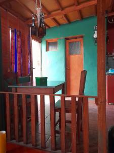 a dining room with a wooden table and a green wall at Sumaj Rústica in Maimará +5 photos
