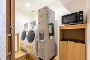a laundry room with a washer and dryer and a tv at Rinn Niomon in Kyoto