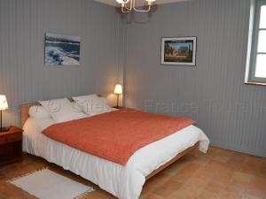 een slaapkamer met een bed met witte lakens en een oranje deken bij Gîte Parçay-sur-Vienne, 5 pièces, 8 personnes - FR-1-381-262 in Parçay-sur-Vienne