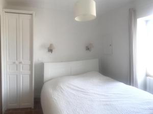 ein weißes Schlafzimmer mit einem weißen Bett und einem Fenster in der Unterkunft Gîte Parçay-sur-Vienne, 3 pièces, 4 personnes - FR-1-381-440 in Parçay-sur-Vienne