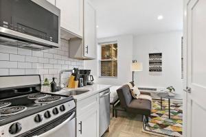 una cucina bianca con piano cottura e lavandino di Cozy Studio Apt with In-Unit Laundry and Wi-Fi! - Montrose 111 a Chicago