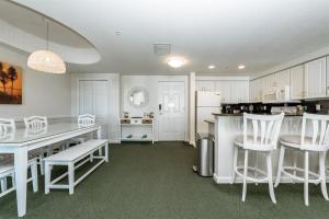 a kitchen with white cabinets and a table and chairs at Unit 2430 Ocean Walk - 2 Bedroom Ocean View in Daytona Beach