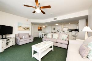 a living room with white furniture and a flat screen tv at Unit 2430 Ocean Walk - 2 Bedroom Ocean View in Daytona Beach