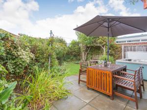 a patio with a table and an umbrella at Dunlin in Burnham on Sea