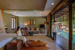 a man and a woman standing in a bedroom at Mountain Creek Golf Resort & Residences in Si Khio