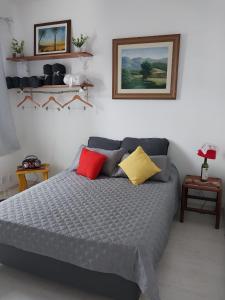 a bedroom with a large bed with red and yellow pillows at Apartamento aconchegante em Petrópolis in Petrópolis