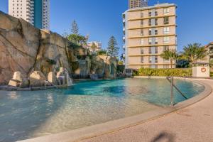 a pool in the middle of a city with buildings at Wings Apartments - QStay in Gold Coast