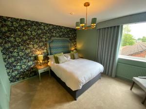 um quarto com uma cama grande e uma janela em The George Hotel Easingwold em Easingwold