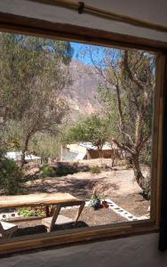 - une vue sur une table de pique-nique depuis la fenêtre dans l'établissement Dormir con llamas, à Maimará