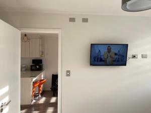 einen an der Wand hängenden Fernseher in einer Küche in der Unterkunft departamento excelente ubicacion in Puerto Montt