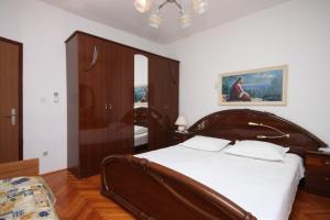 ein Schlafzimmer mit einem großen Holzbett mit weißer Bettwäsche in der Unterkunft Twin Room Kustici 6288a in Kustići