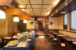 un comedor con una larga mesa llena de comida en HOTEL MYSTAYS Sakaisuji Honmachi, en Osaka