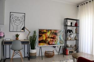 a living room with a tv and a desk at The Red Portrait at Carlswald in Midrand