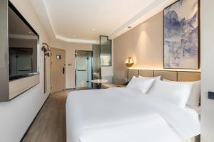 Ліжко або ліжка в номері Xinhuating Business Hotel