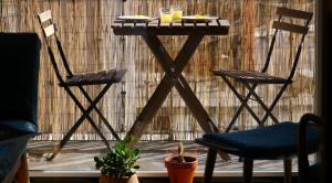 two chairs and a table with two drinks on it at Cacilhas Guest Apartments in Almada