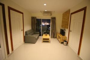 a living room with two doors and a couch and a table at Lee Place Phatthanakan Condo in Bangkok