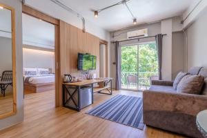 uma sala de estar com um sofá e uma mesa com uma televisão em @Aonang Guesthouse em Praia de Ao Nang